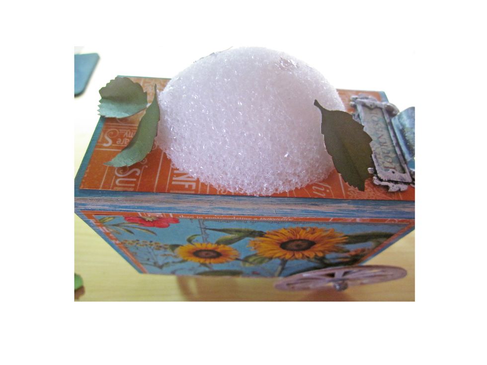 Using either a hot glue gun or some type of strong glue start gluing a base of leaves on your egg.