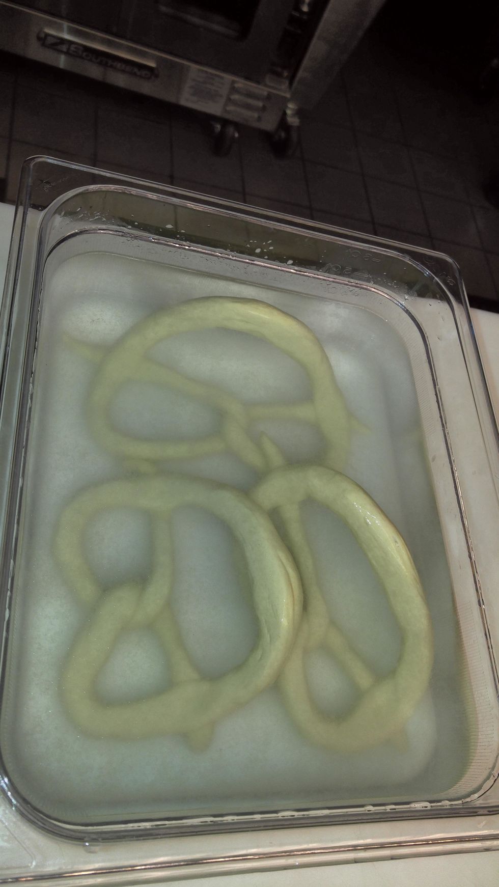 Using gloves, dip the pretzels for 45 seconds. The lye solution gelatinizes the surface starch. Chilling the dough ahead of time makes it easier to handle the raw pretzels.