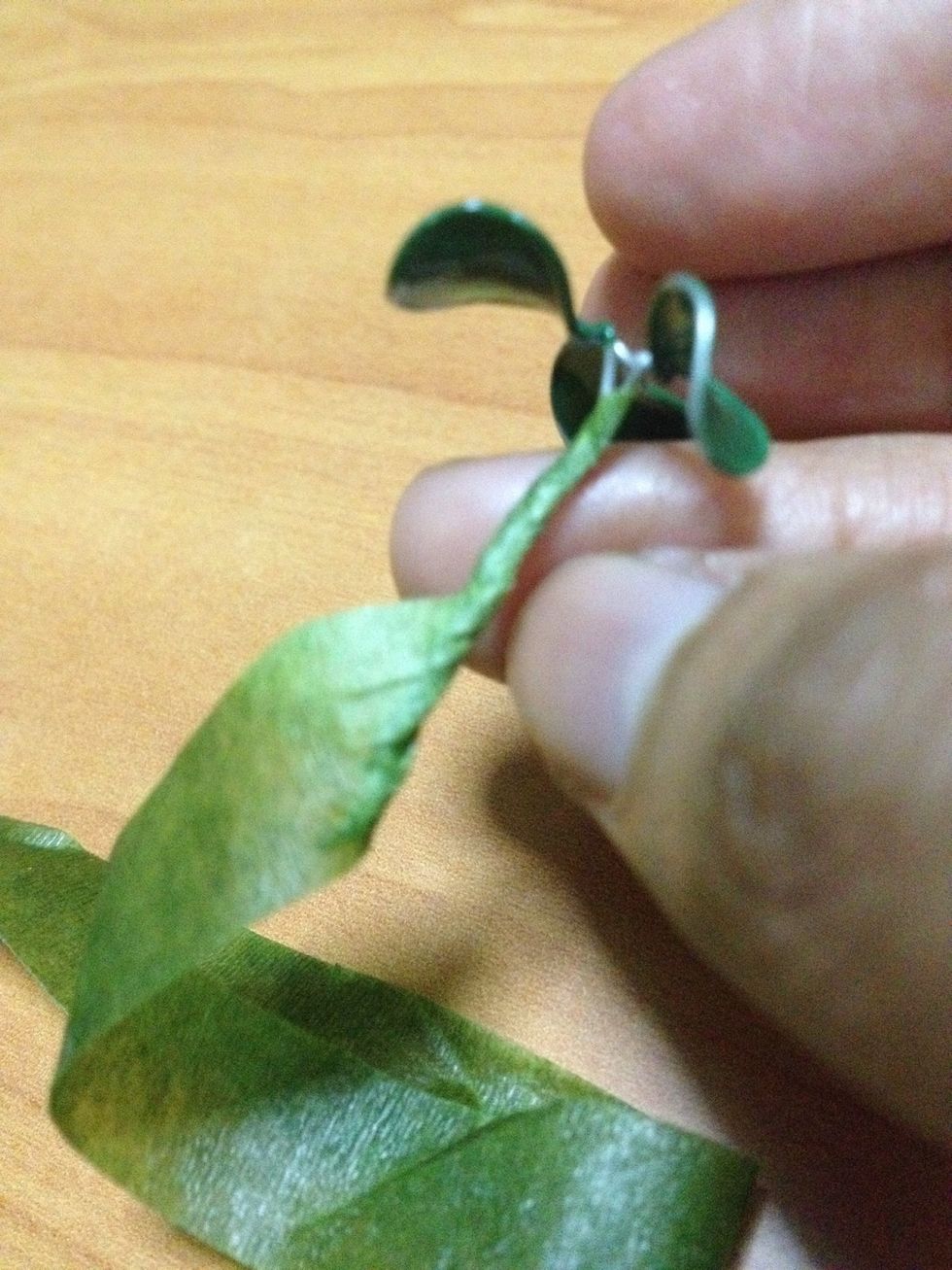 Using green tape, tape along the stem of the flower to cover up the wires. Stretch along diagonally to save tape \ud83d\ude09