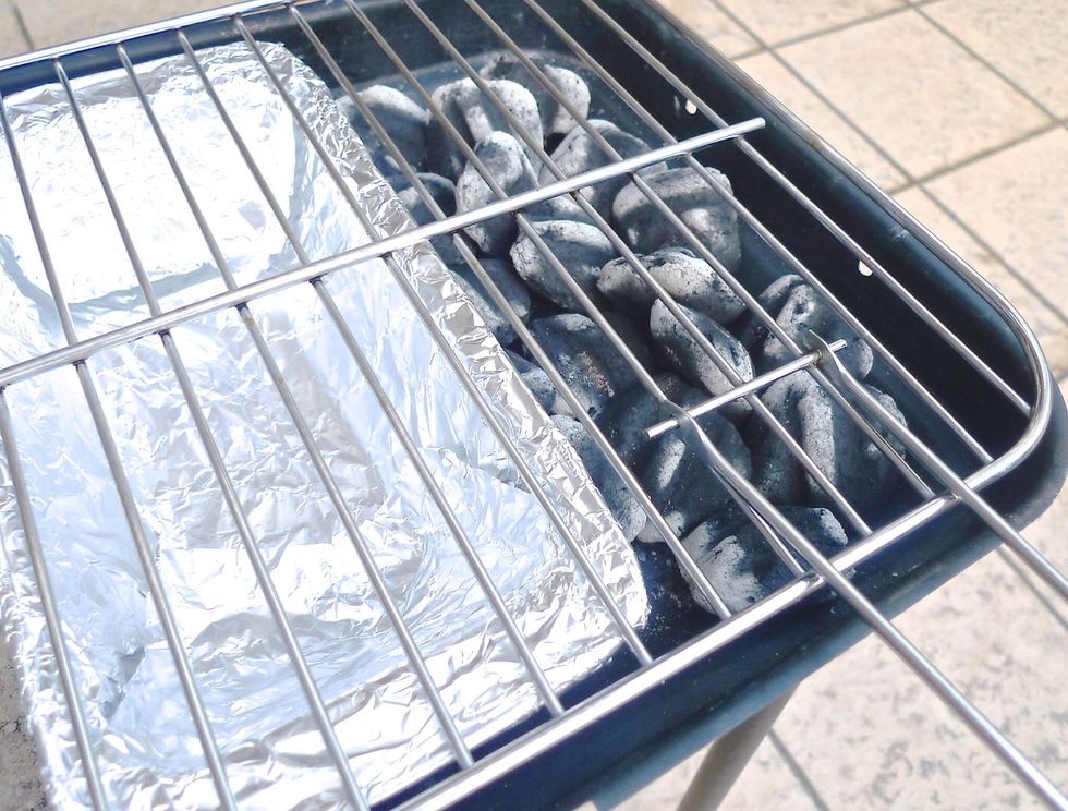 Using grilling gloves, carefully put the grilling grate in its place. Now the charcoal grill is all set.