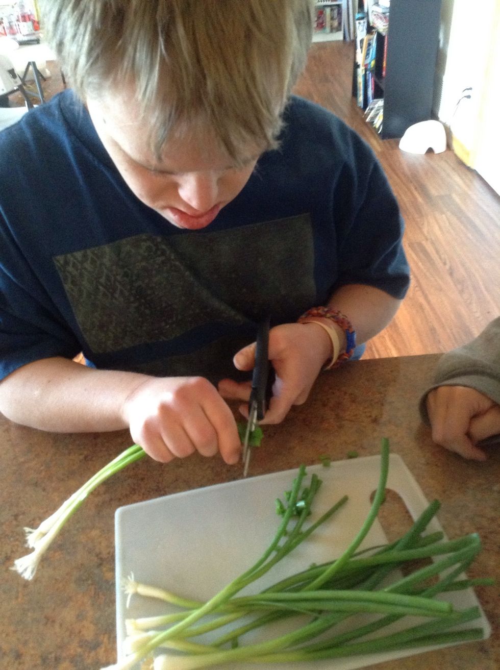Using kitchen scissors cut the green onion into slices the width of an eraser