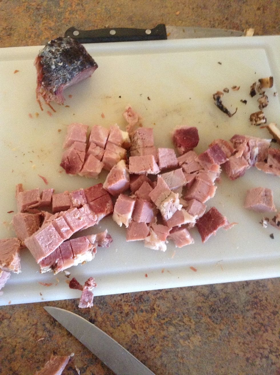Using knife and cutting board cut ham into small squares