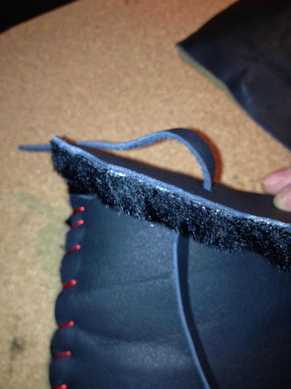 Using left over leather scraps, cut a long, thin leather piece making a string. Then thread it through the newly-made hole.