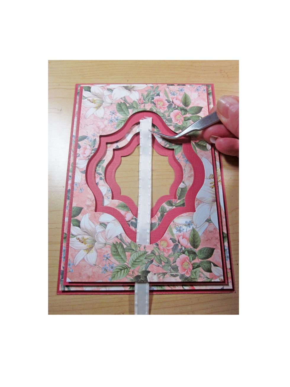 Using May Arts Ribbon take a fine tip pair of tweezers and run your ribbon through the center of the card as shown.