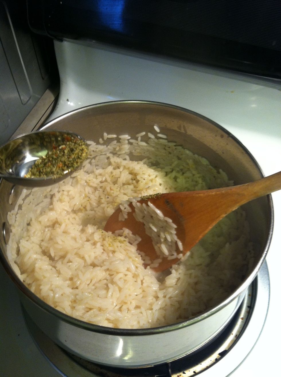 Using one hand stir the rice and slowly sprinkle in the Mrs. Dash