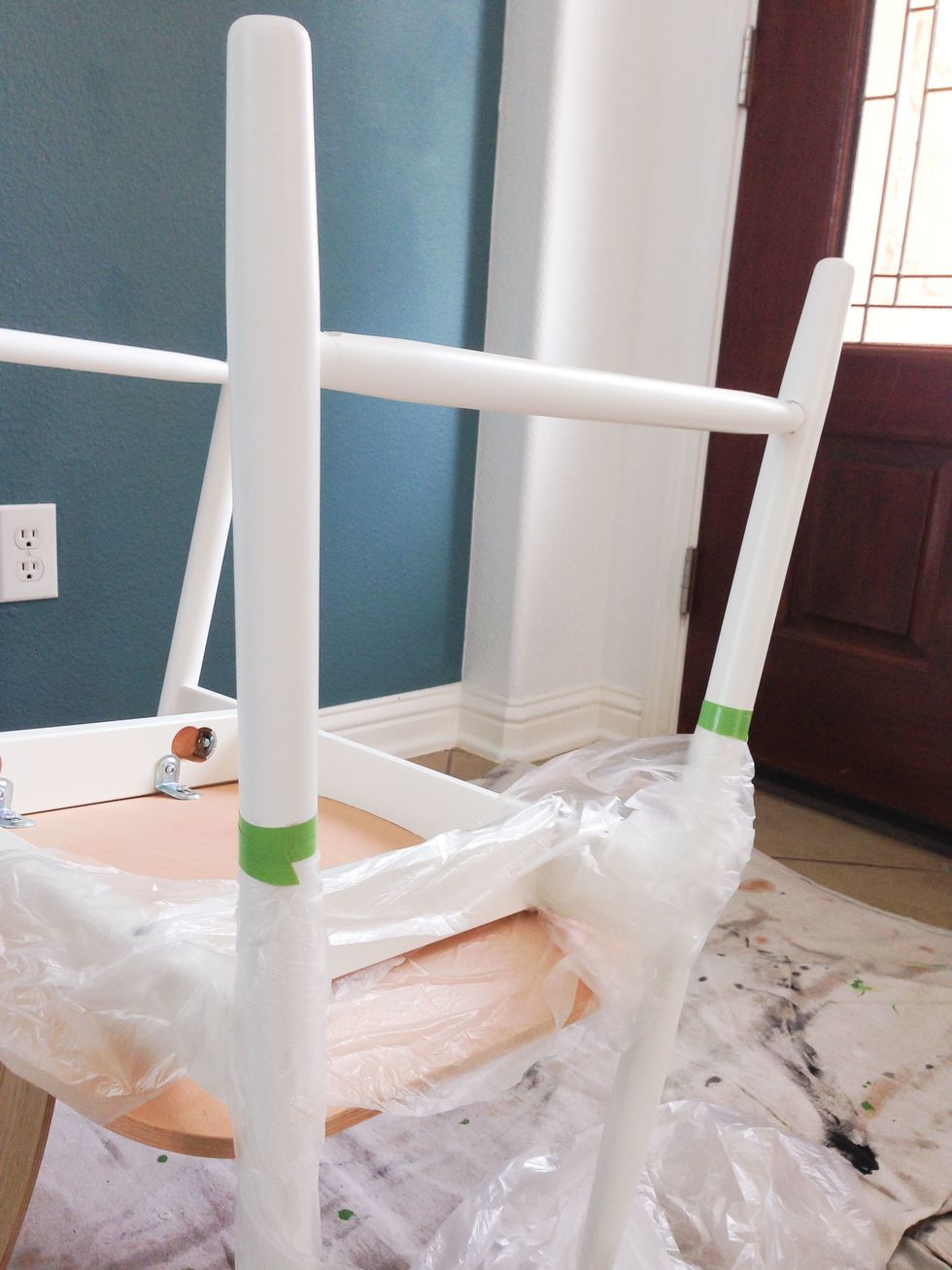 Using painters tape, tape off a straight line on the chair legs where you want the dipped paint look to end. I used a ruler to make sure both legs were even. I also covered the chair in plastic.