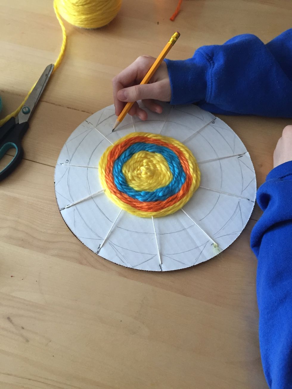 Using pencil, draw a radial design around your weaving.