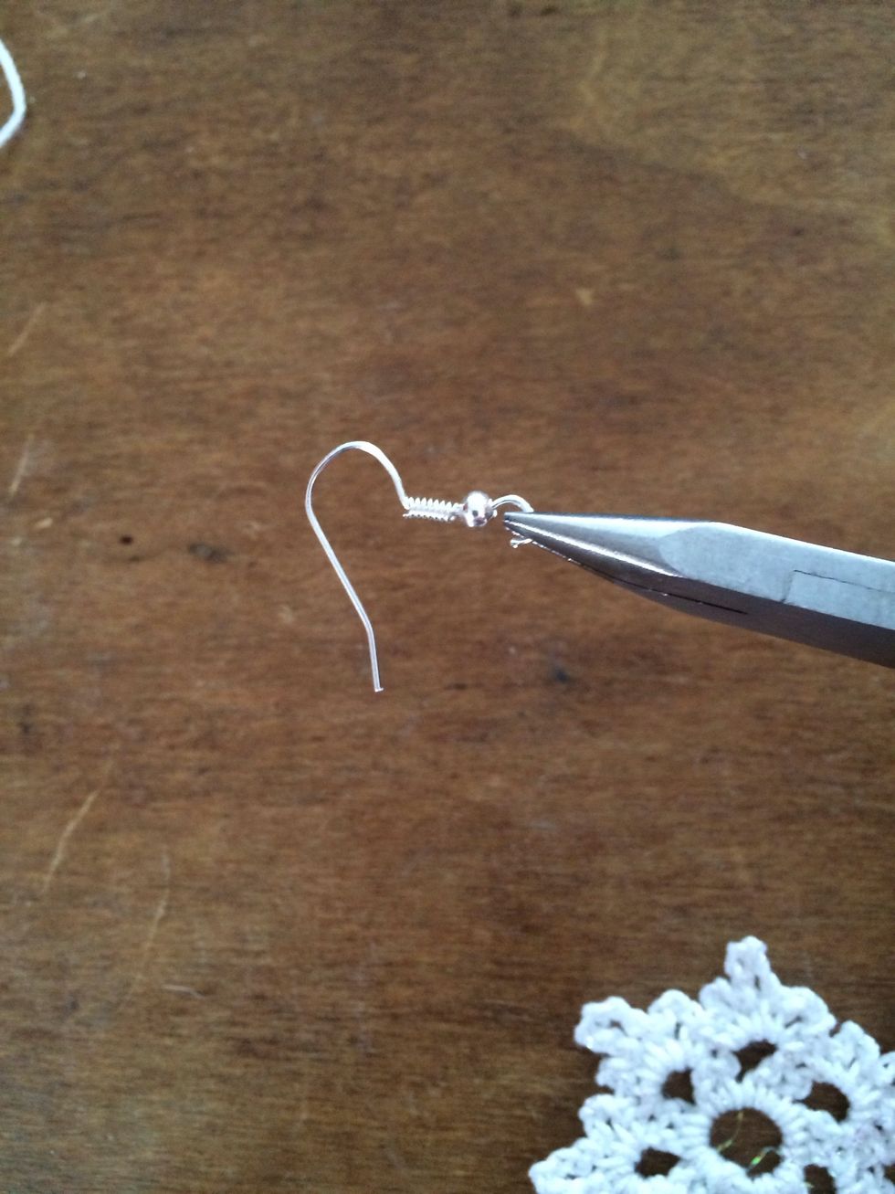Using pliers, open the loop at the bottom of the fishhook earrings. Loop one of the points of the snowflake through the fishhook earring.