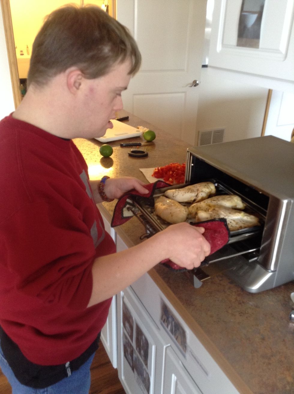 Using pot holders grab the baking sheet out of the oven