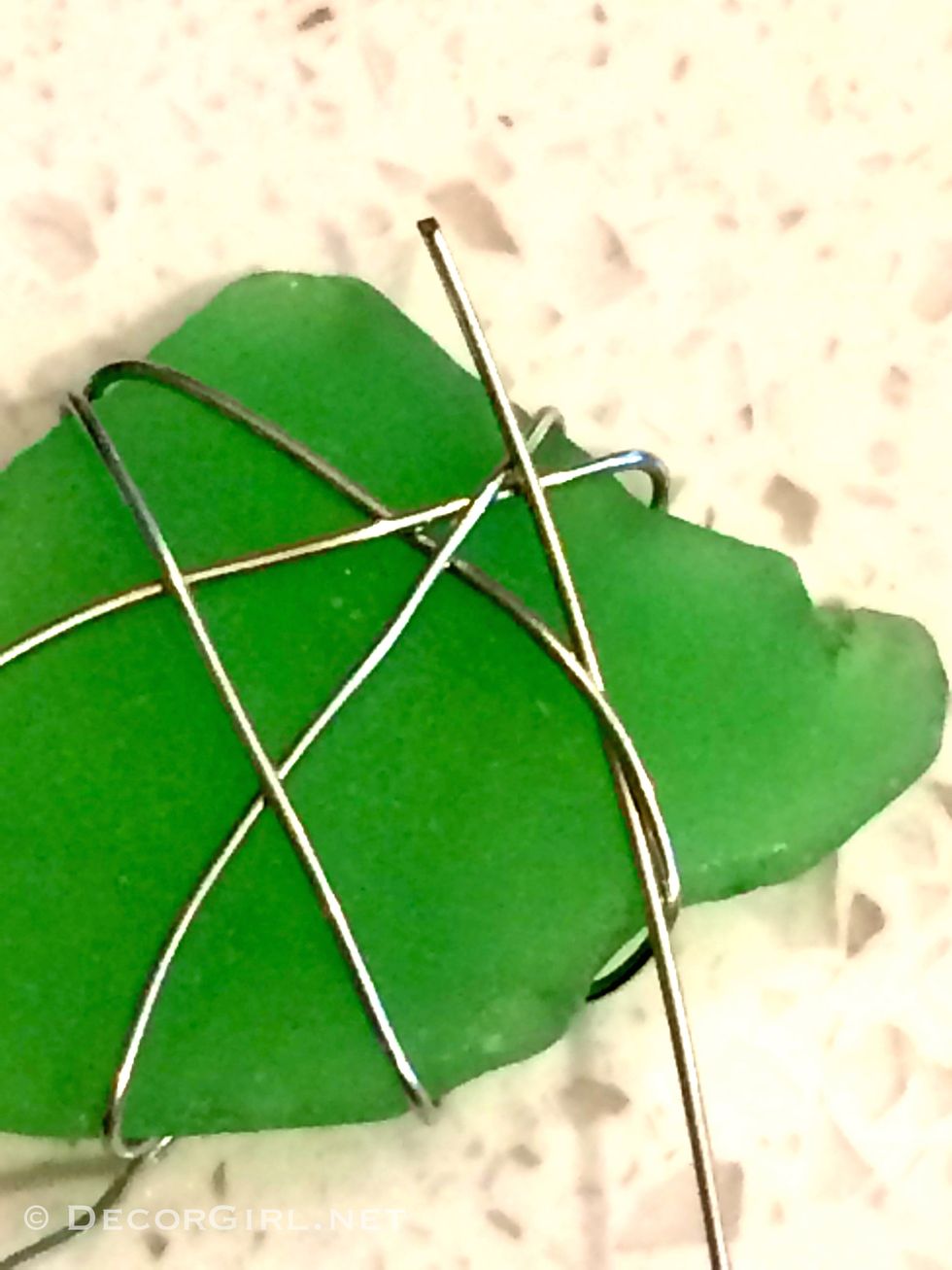Using random lengths of wire (4" - 6") artistically wrap each piece of sea glass tucking under end of wire and pulling through on the last wrap around on each piece.