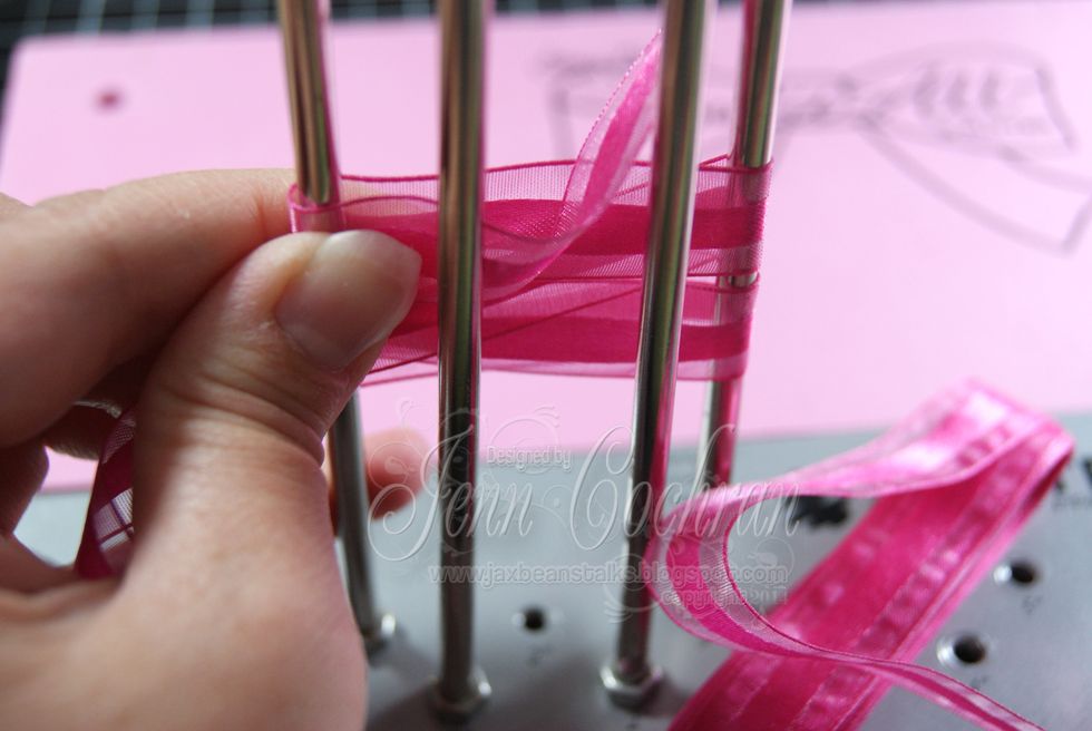 Using Really Reasonable Ribbon's Sheer Ribbon with a Satin Center in Fuchsia, create a bow with the Bow It All from Zutter.  Both are found on the RRR site: www.reasonableribbon.com.