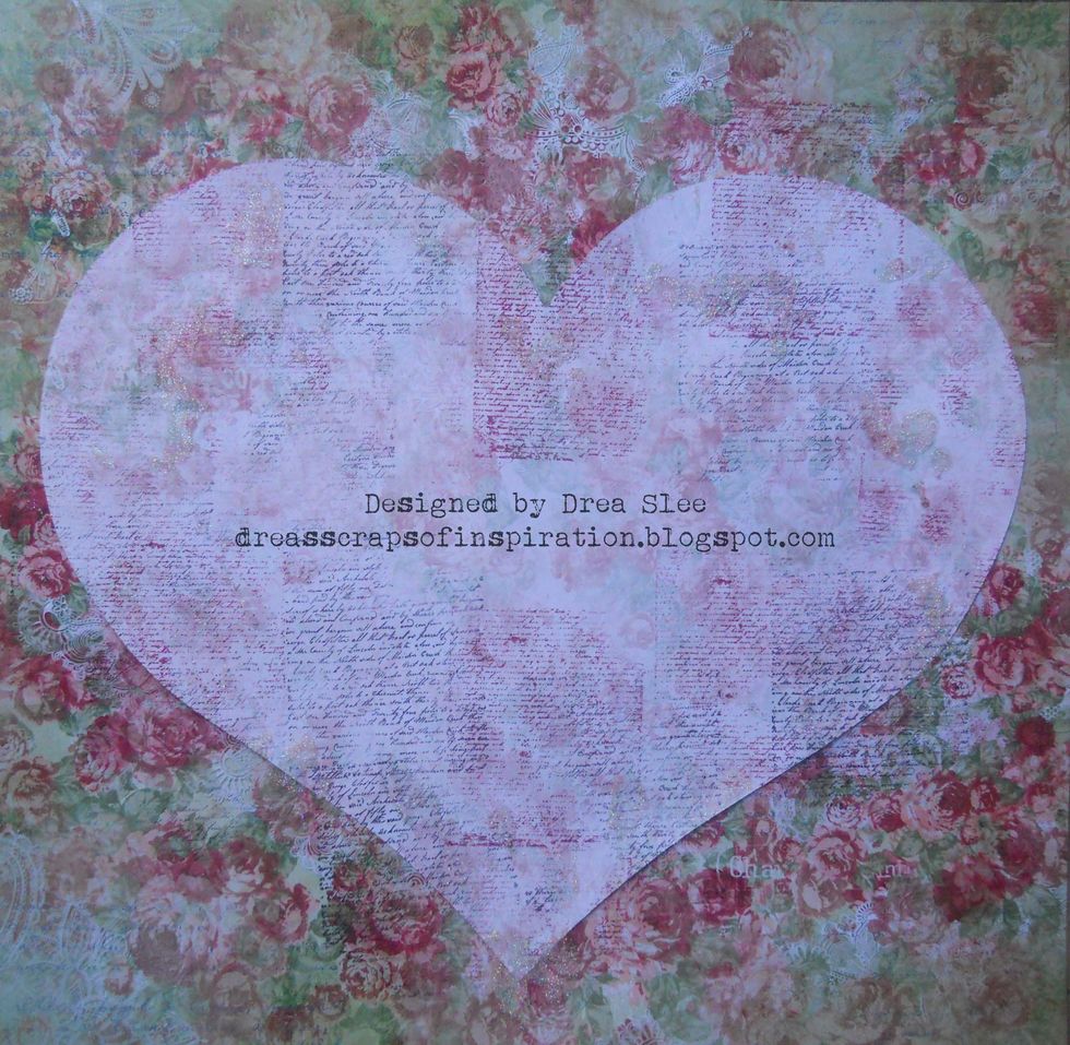 Using script stamps in red and black permanent inks, randomly stamp over the heart and background. Apply splatters and textures with a popsicle stick, using Bo Bunny Glitter Paste in Sugar.