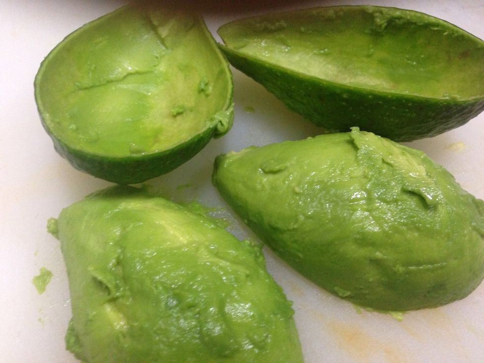 Using spoon, scoop avocado from skin