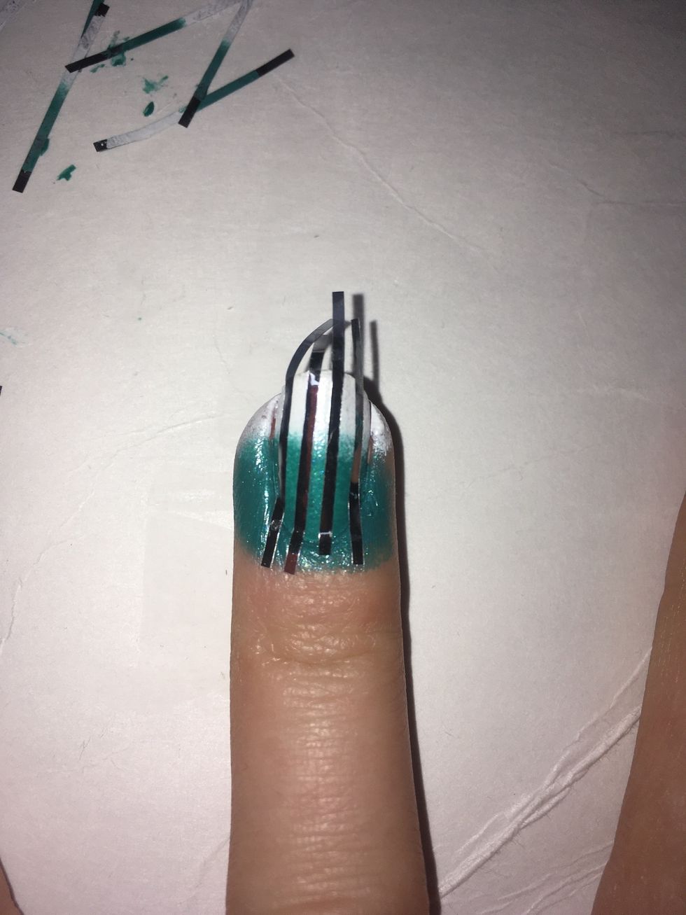 Using strips of tape, stick them on to make straight vertical lines on your nails, it's harder than it looks to get the lines straight!