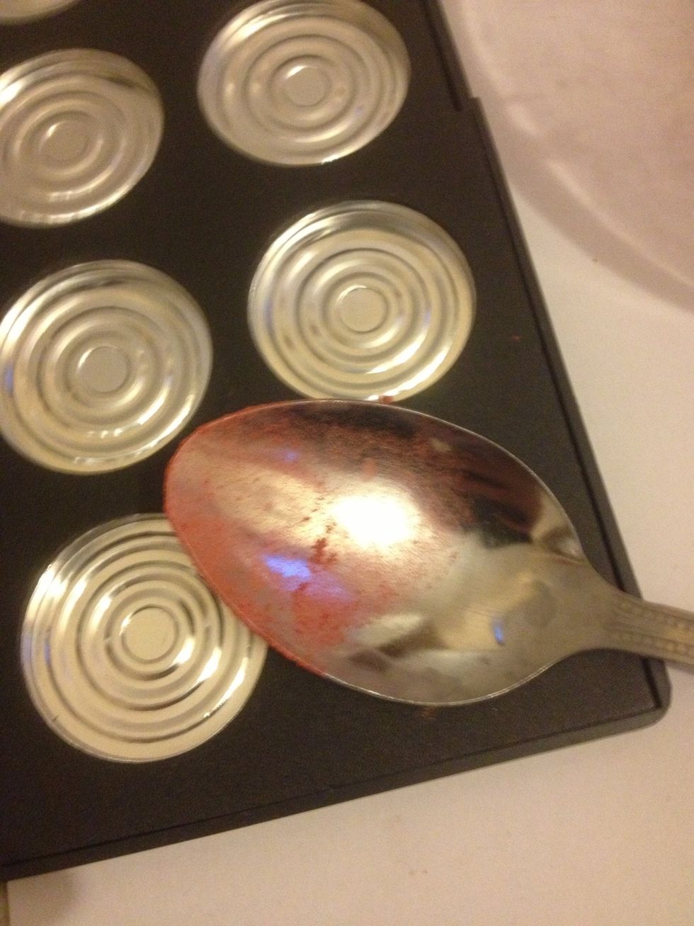 Using the back of the spoon compact the powder by pressing down