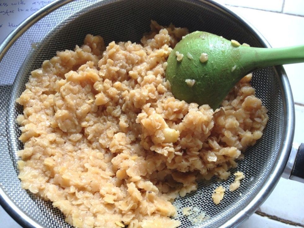 Using the back of wooden spoon, drain the excess water through a sieve