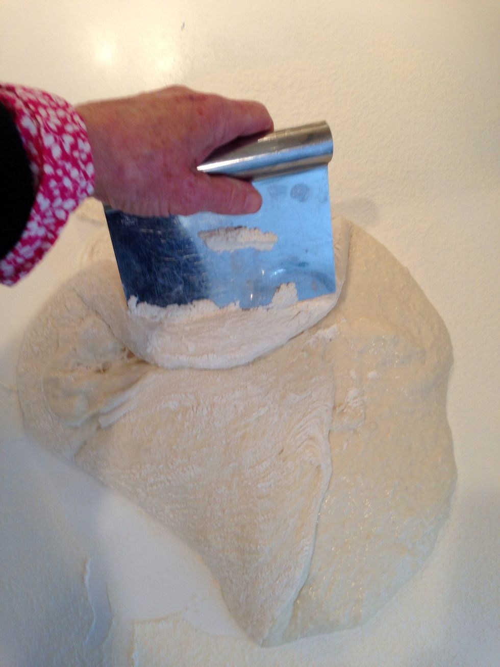 Using the bench scraper, fold it onto itself. You only need to do it 3 or 4 times. Just until it's all covered in flour.