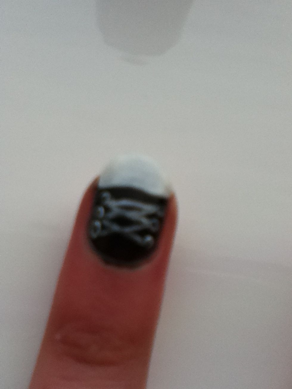 Using the black, dab three smaller dots into the white dots.