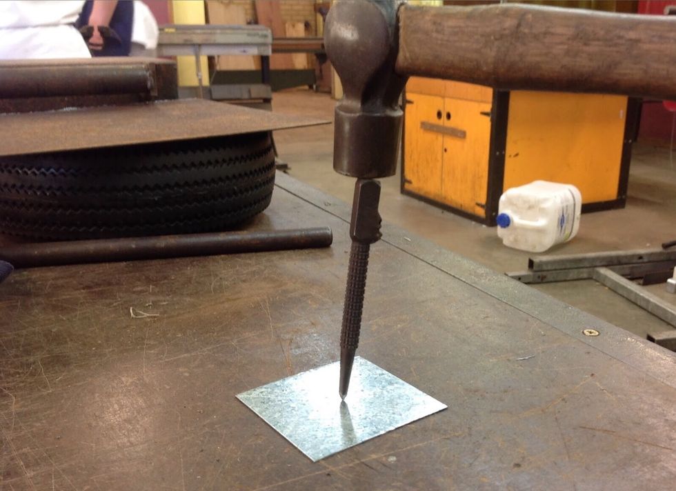 Using the centre punch create an indent in the centre of the cross.