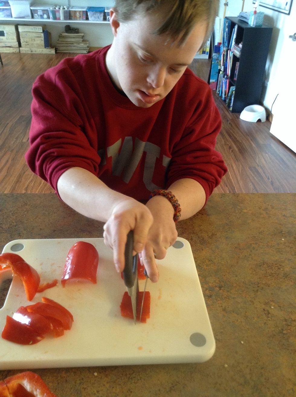 Using the cutting board, knife, and cutting guide cut the red pepper into small pieces