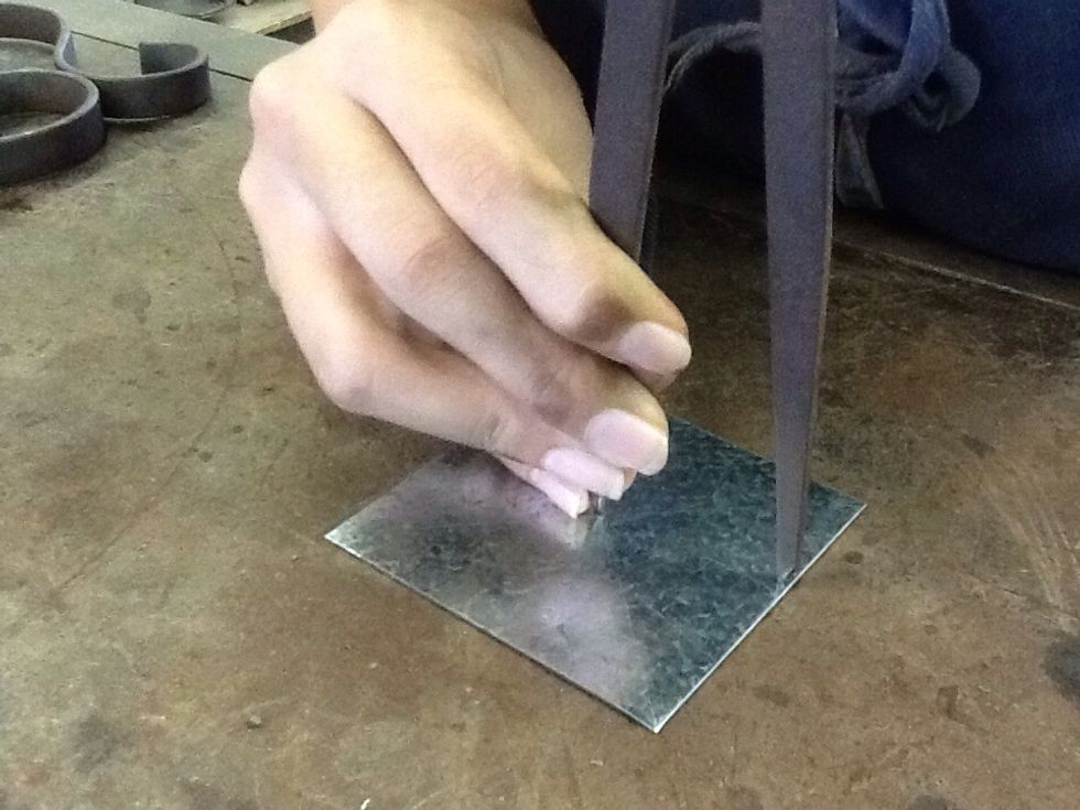 Using the divider, mark a circle into the metal