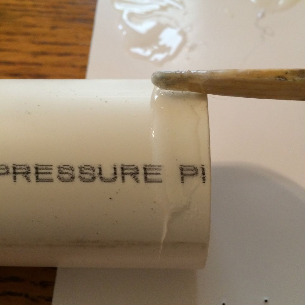 Using the end of a popsicle sized stick, evenly spread a modest amount of glue on one end of the PVC pipe.