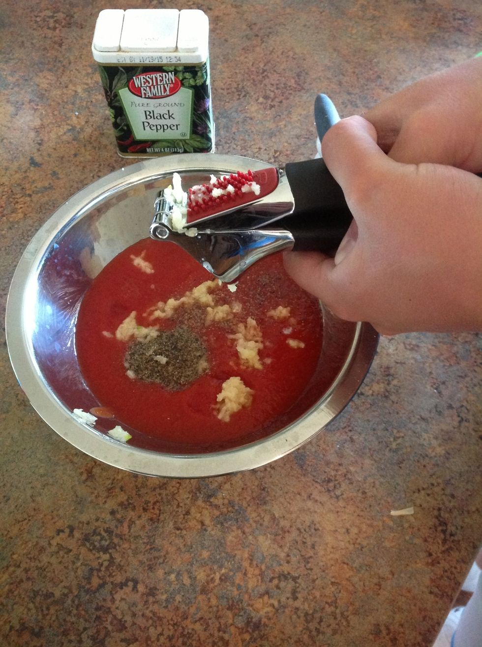 Using the garlic press, press the garlic into the bowl the sauce.