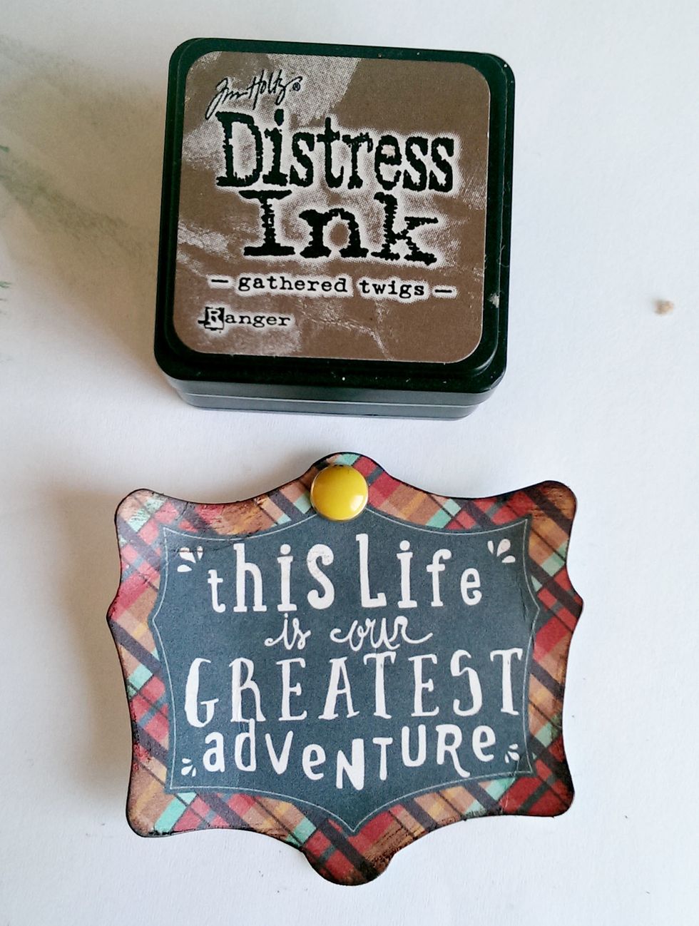 Using the Gathered Twigs Ink, ink the edges of this saying found in the Brads package. Use your finger to round up the edges.