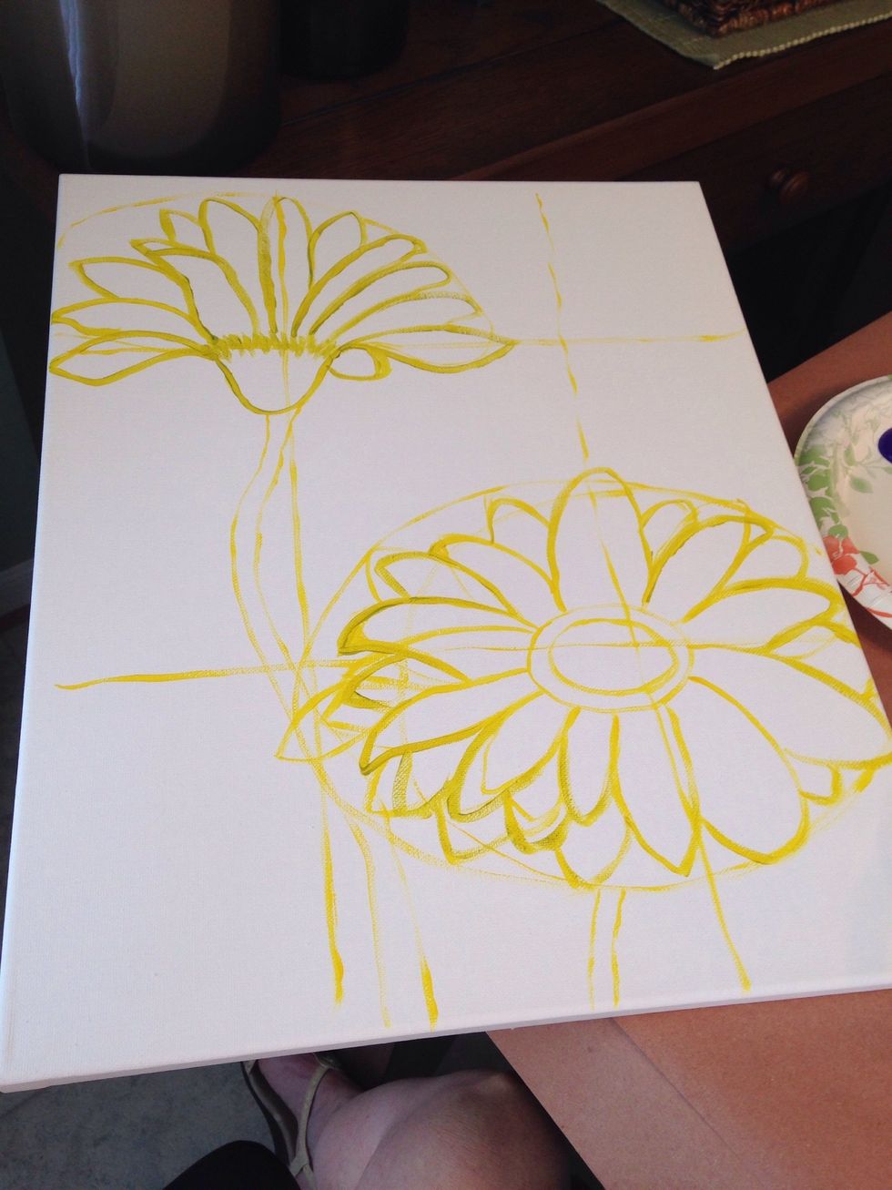 Using the grid lines as a guide, draw the outline of the flowers and stem with the yellow paint and regular sized paint brush.