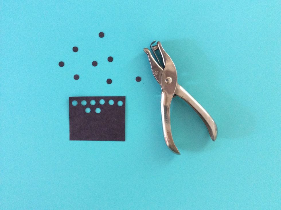 Using the Hole punch, make 8 circles using black paper.