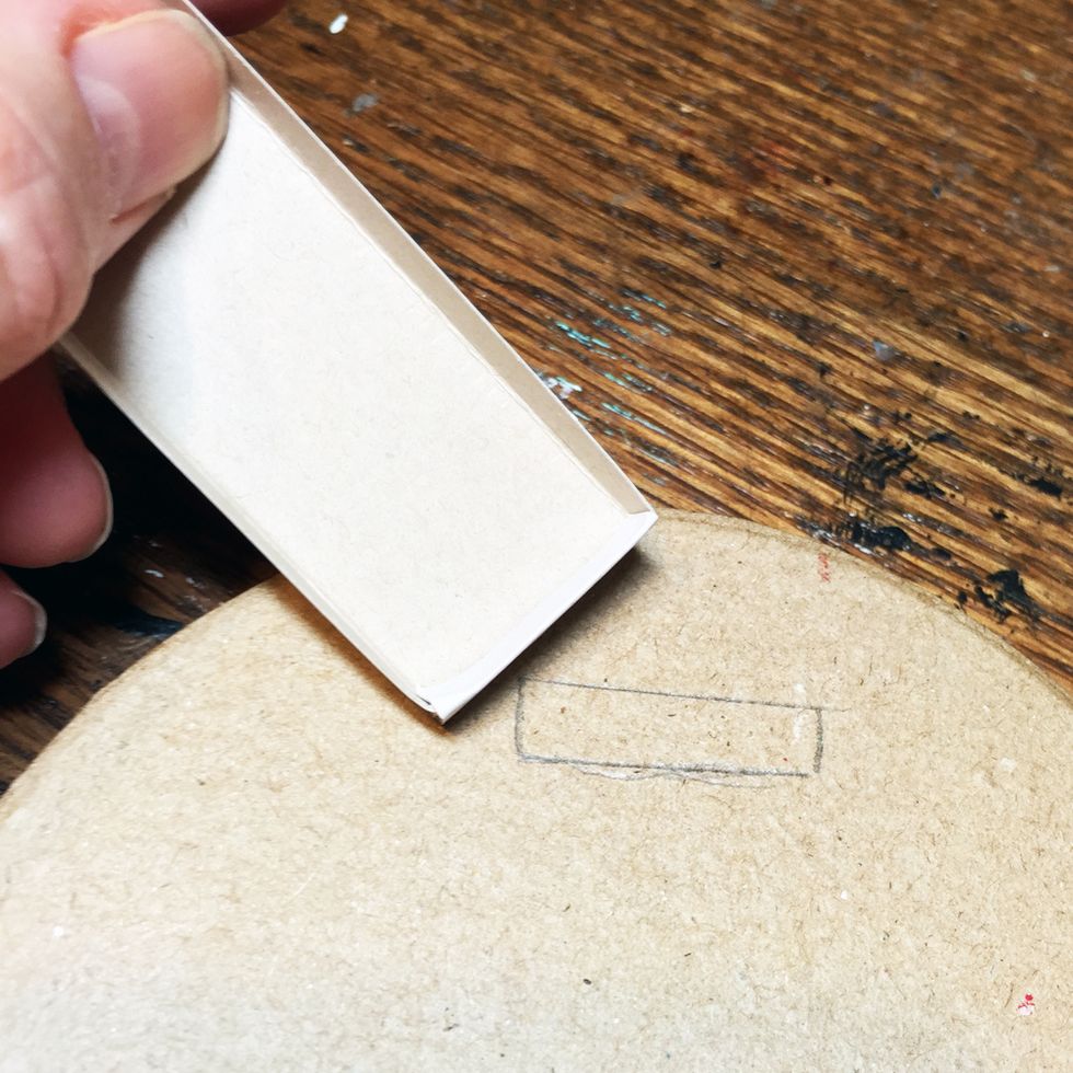 Using the inside of one of the matchboxes, trace around the bottom of the matchbox where you want the grave stone to go on the paper mache box.