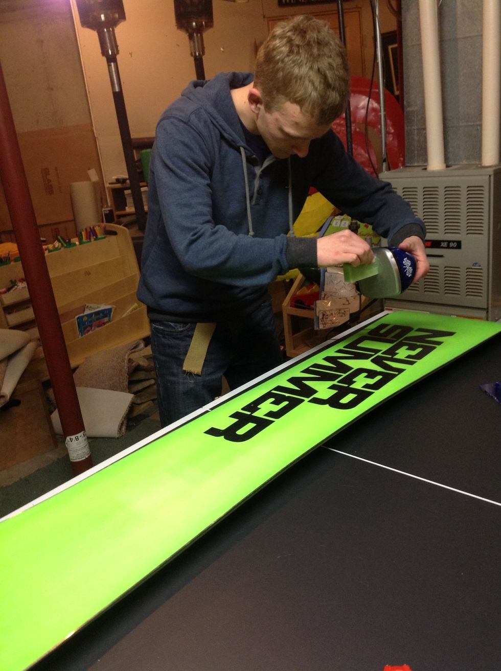 Using the iron drip new wax on the snowboard.