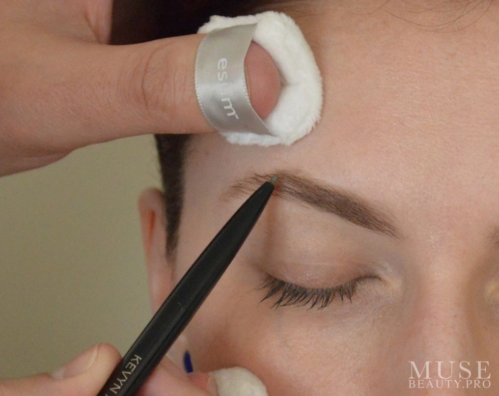 Using the KEVYN AUCOIN Precision Brow Pencil draw in the brow in fine strokes to create a base or low light. Here we are using the Brunette pencil.