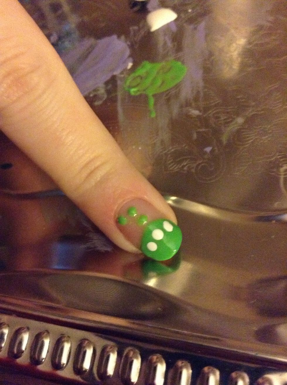 Using the large end of the dotting tool (or a toothpick) add three white dots to the alien's head, following the curve of the head. These will become the eyes.