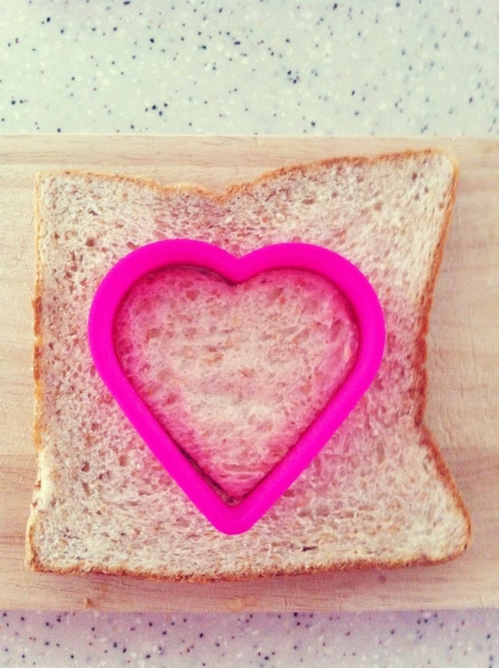 Using the mould, cut a heart out of the bread.