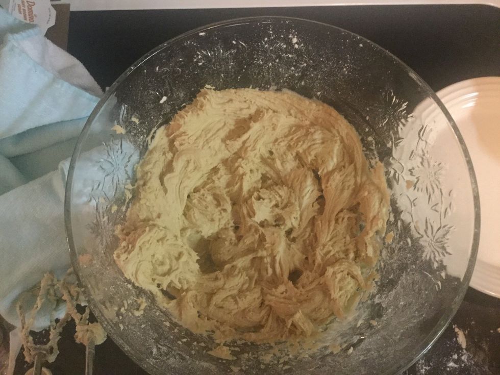 Using the normal mixer beaters, mix the mixture in the larger bowl and gradually add the flour mix and continue mixing until creamy.