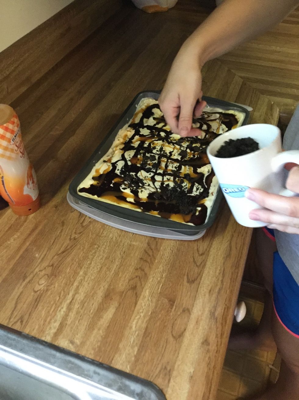 Using the Oreos in the cup, sprinkle on top of ice cream and syrup.