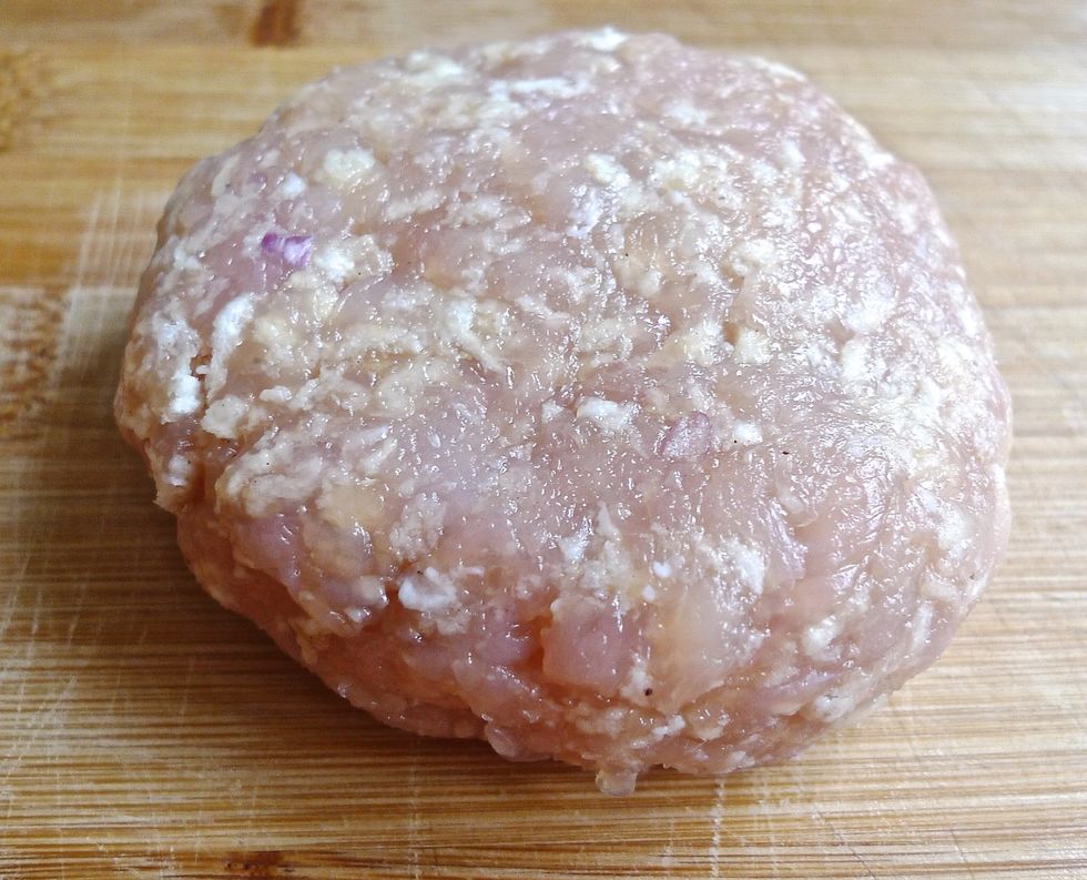 Using the palm of your hand, press down on the top of the ball and make it into a disk. Then using your fingers, smooth and shape the outside edges of the patty until it is perfectly round.