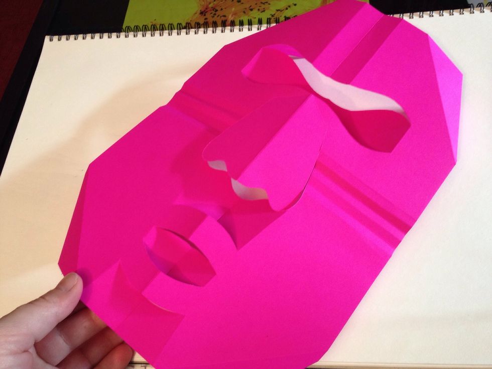 Using the perforations, loosely fold the mask into shape- dotted lines folded towards you, dashed folded away.