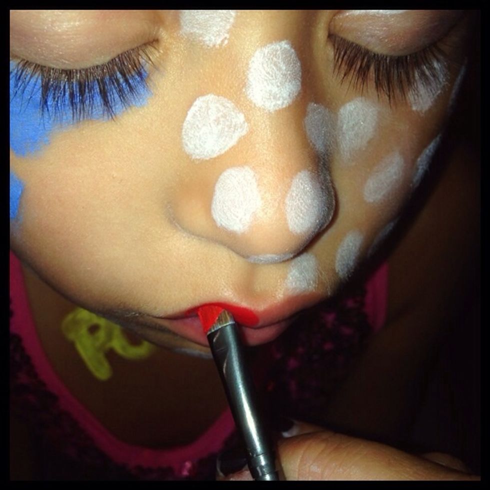 Using the red paint fill in the lips