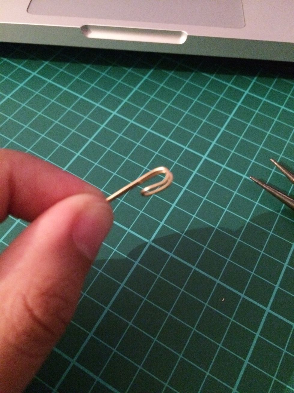 Using the round nose pliers, about 2cm down the curved side of the wire, bend it inwards without looping it completely. In sort of a hook shape.