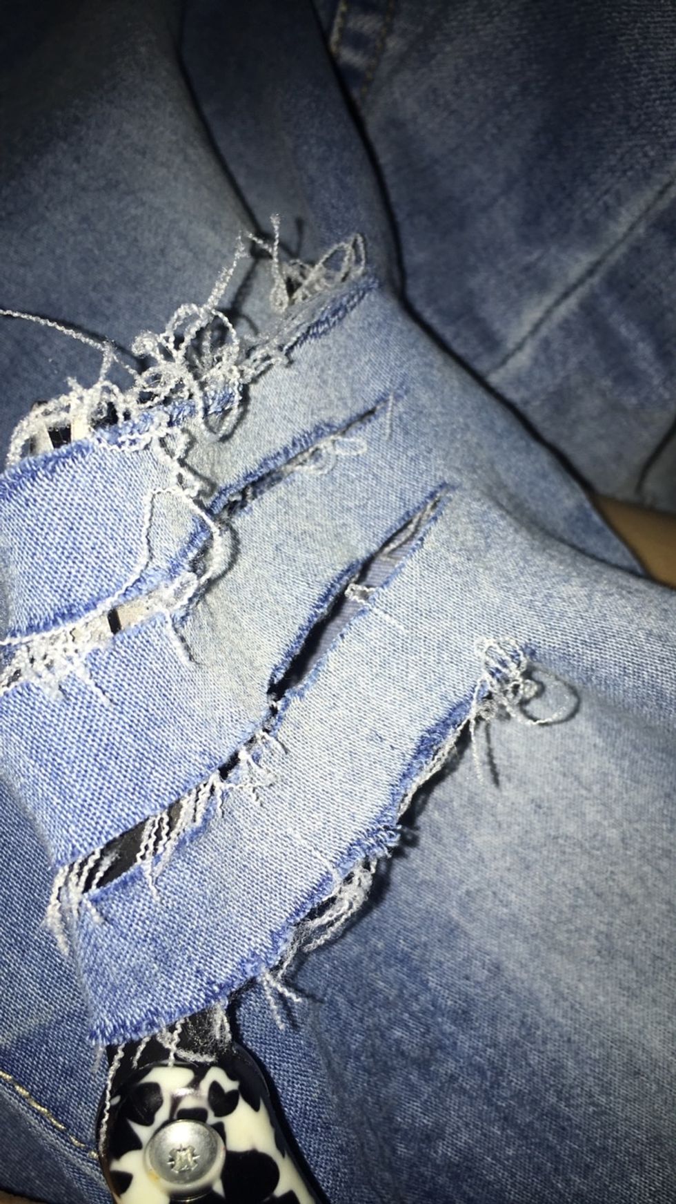 Using the scissors, make horizontal cuts along the jeans where the distress is desired.