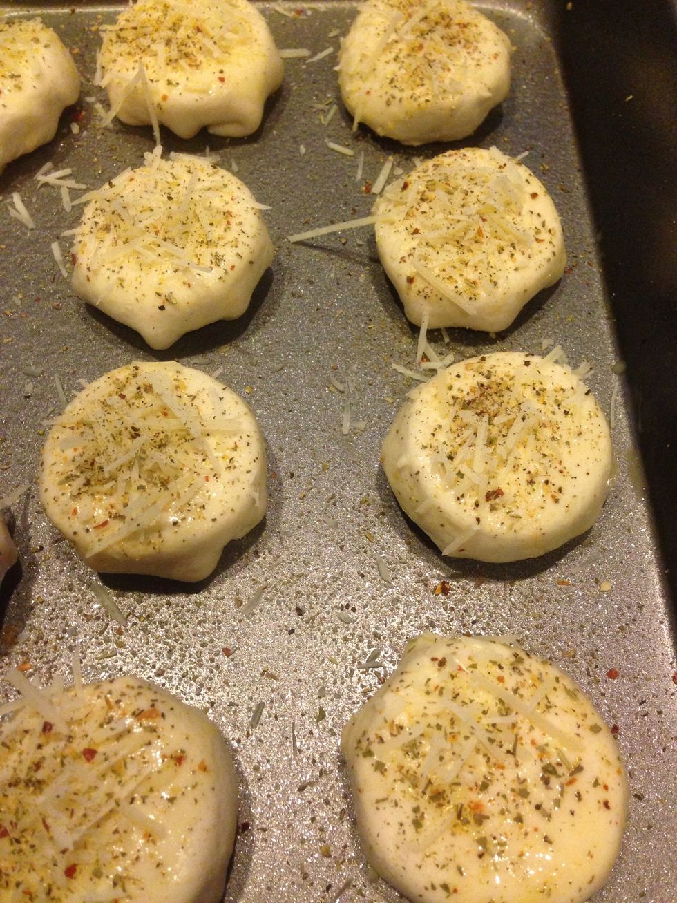 Using the scrambled egg, use a basting brush to wash the top and sides. Sprinkle with ground Italian seasoning and garlic powder. Top with a Pinch of grated parmesan. Bake at 425F for 10-12min.