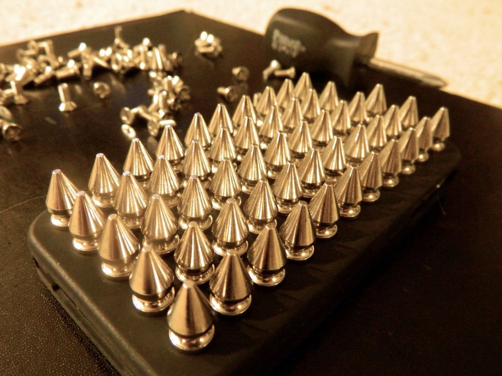 Using the screw driver, unscrew the studs and push them through each hole.