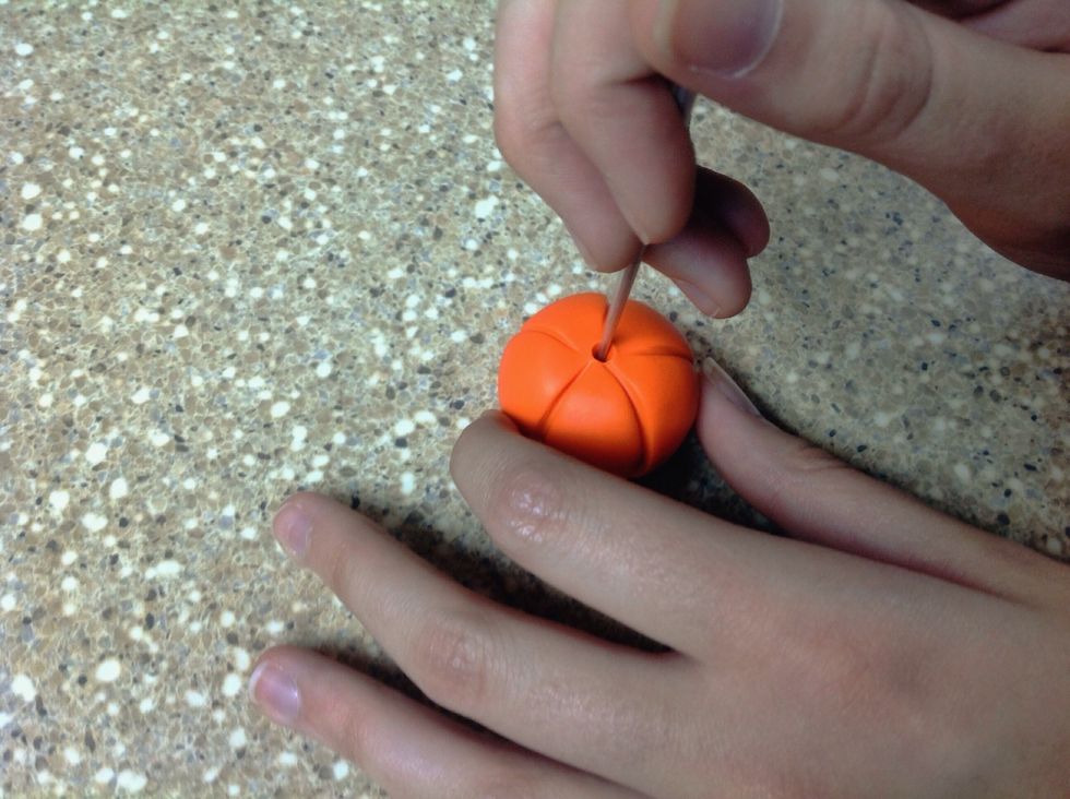 Using the sharp tip of the sculpting tool, poke a hole in the top of the pumpkin. Push the tip in and make slow circular motions with the tool to make the hole large enough to insert the stem.
