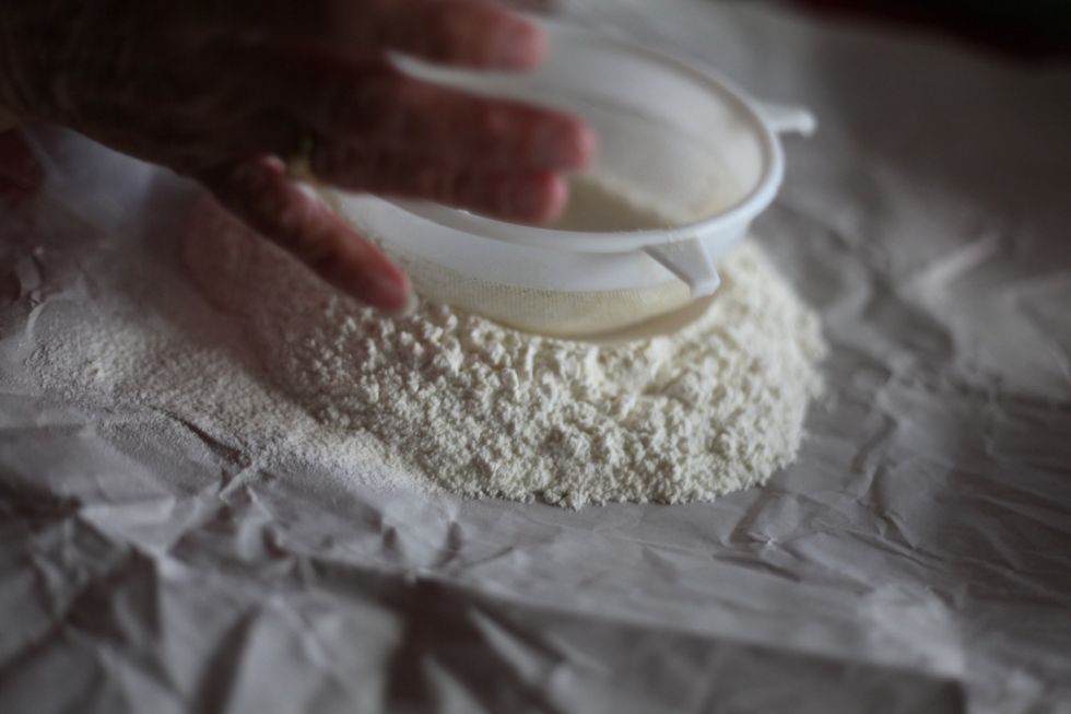 Using the sieve to make a well in the centre.