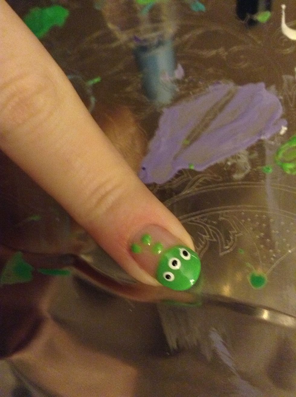 Using the small end of the dotting tool (or toothpick) place smaller black dots on top of the white dots. These are the eyes.