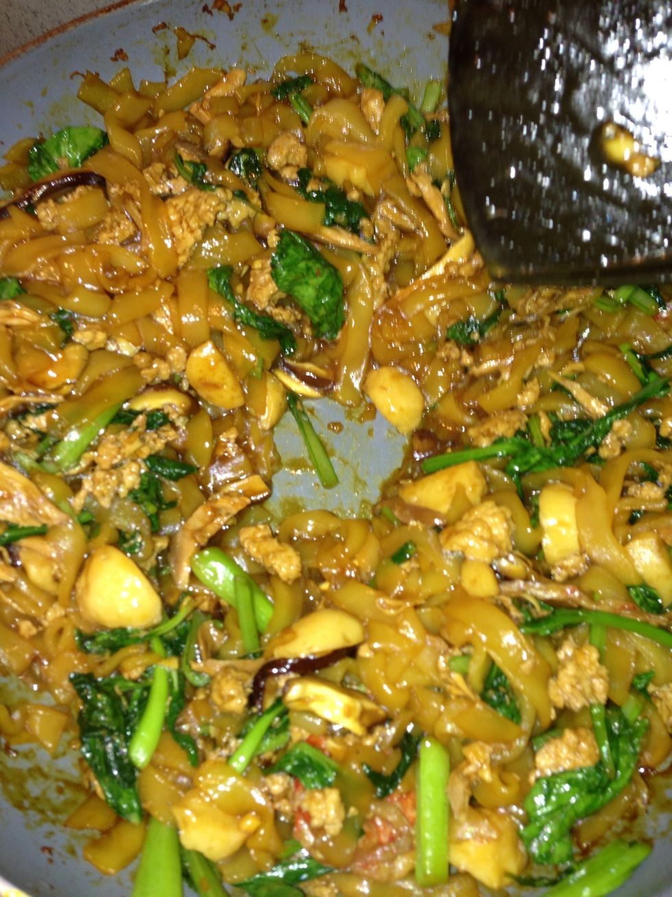 Using the spatula, push the noodles to one side, and add a 1 tablespoon of oil on the empty area and crack an egg on it.