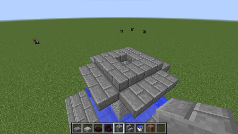 Using the Stone Brick Slabs build a 3x3 doughnut and ledges sticking out from it.