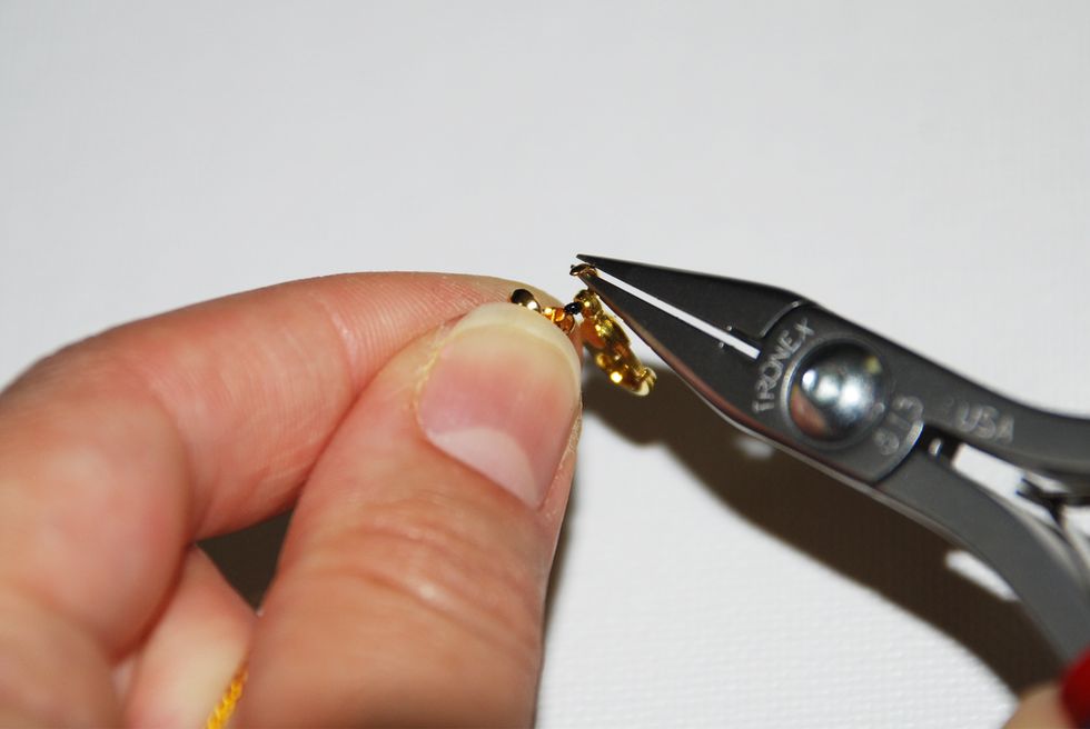 Using the tip of your chain nose pliers, curl the end of the hook so that it encloses the clasp.